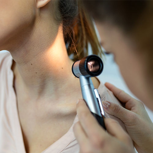 Close up of young woman undergoing a skin cancer chack on her neck